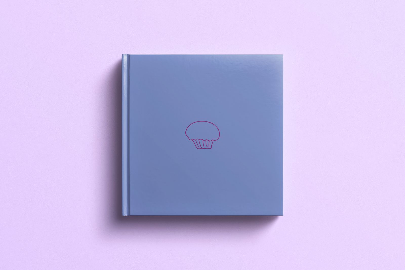 The Muffin Manifesto book cover mockup, blue hardcover with muffin line icon