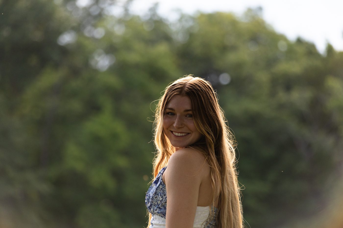 Woman glancing back over her shoulder, smiling in golden hour light