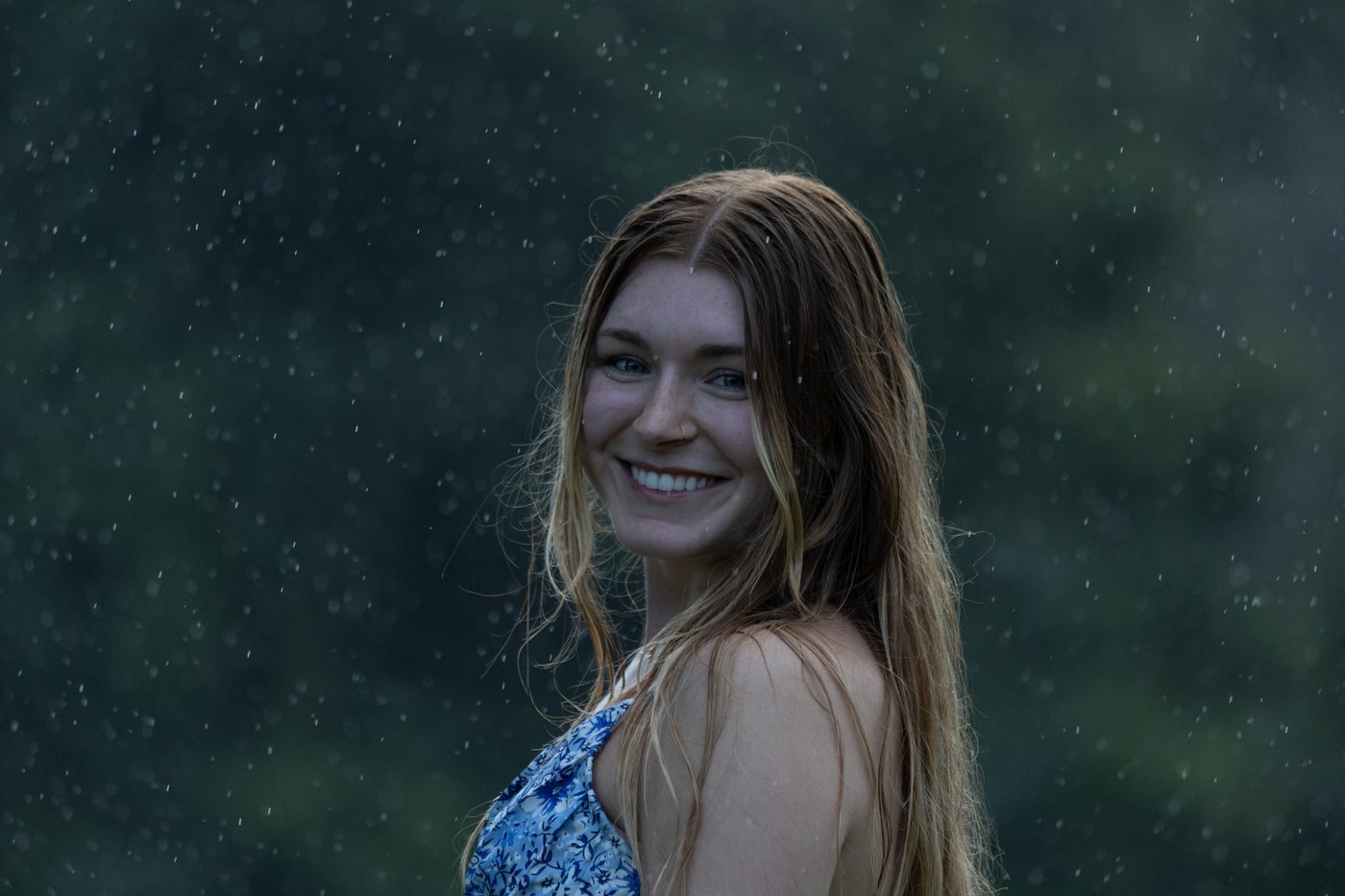 Smiling profile portrait in the rain with visible raindrops
