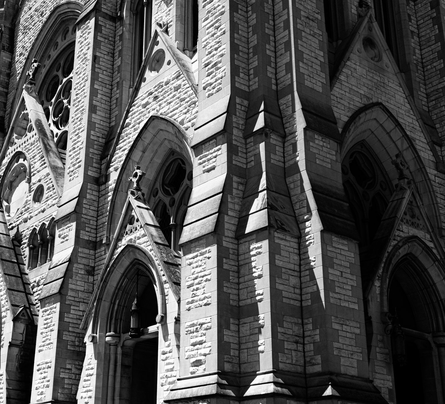 Black and white close-up of a Gothic cathedral facade with arches and spires